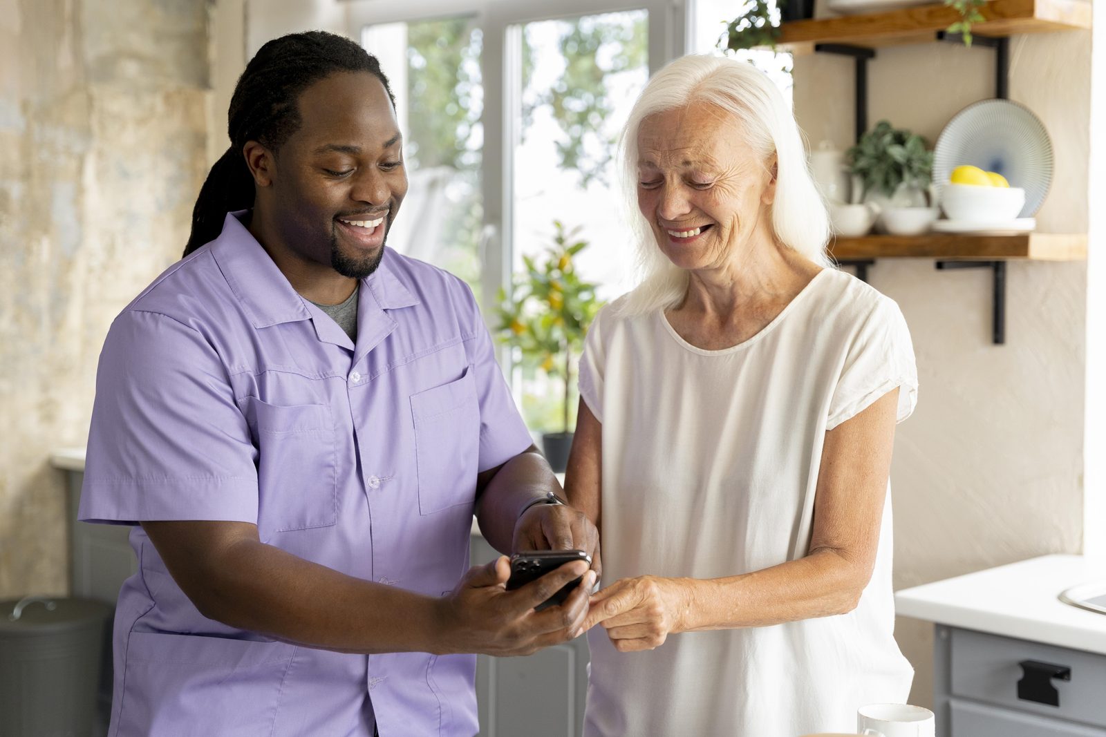 A support worker attentively assisting a senior woman at home
